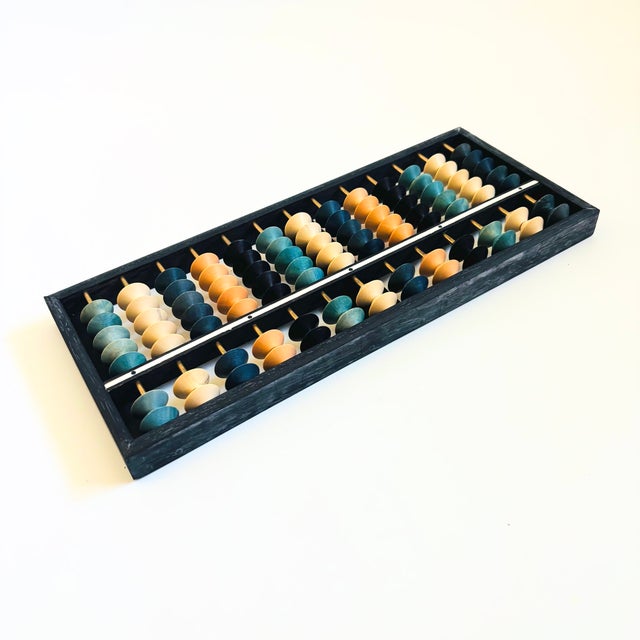 A beautiful vintage Japanese wood abacus. Some of the beads are stained in varying shades of blue. Measures 12"W x .75"D x...