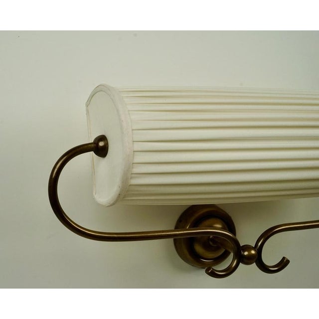 An elegant wall light made with patinated brass and a silk shade, designed by Josef Frank in the 1950's. This beautifully...