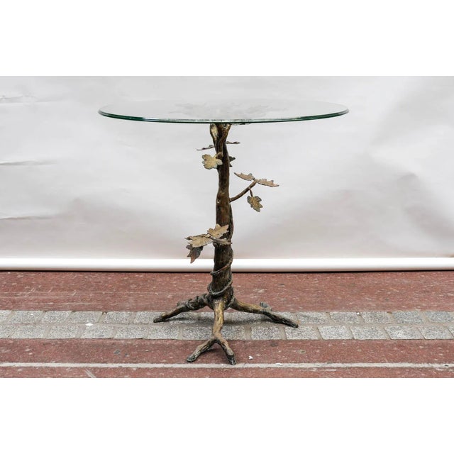 This gueridon features a scuptural base in solid brass.