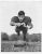 1950s black and white photograph of University of Alabama Crimson Tide tackle George Mason diving for the football. Mason...