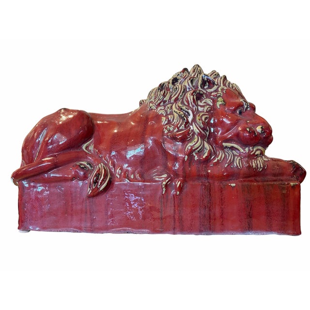 A striking pair of Art Deco-style lions finished in a rich oxblood glaze, showcasing bold sculptural form and streamlined...