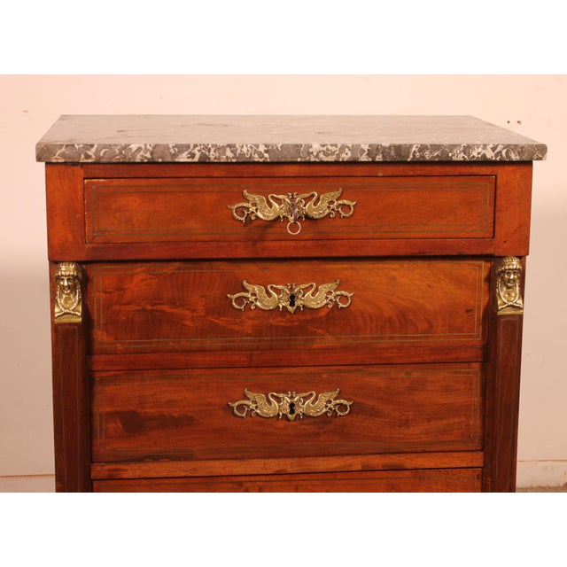A charming small mahogany commode in the empire style, dating from the late 19th/early 20th century. it features four...