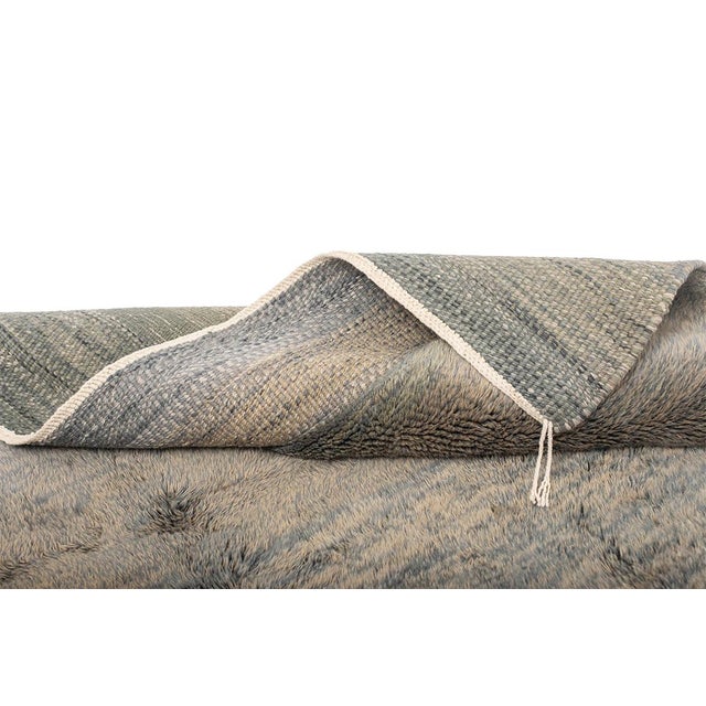 This large contemporary hand-knotted wool rug showcases a refined gradient of forest green, olive tones, cool gray, and...