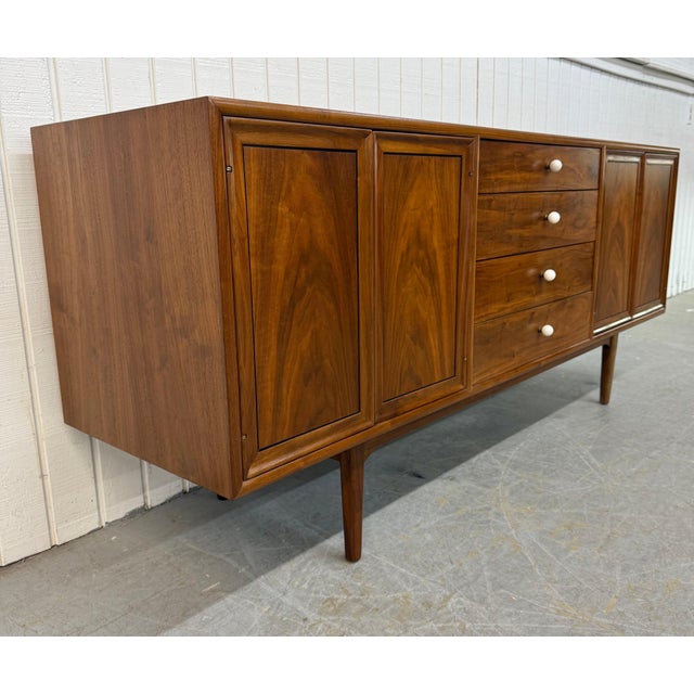 This listing is for a Mid-Century Modern Drexel Declaration Walnut Sideboard. Featuring a straight line design, push doors...