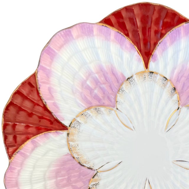 An exquisite turn of the 20th century porcelain dessert or cabinet plate featuring a molded multi-layer seashell motif....