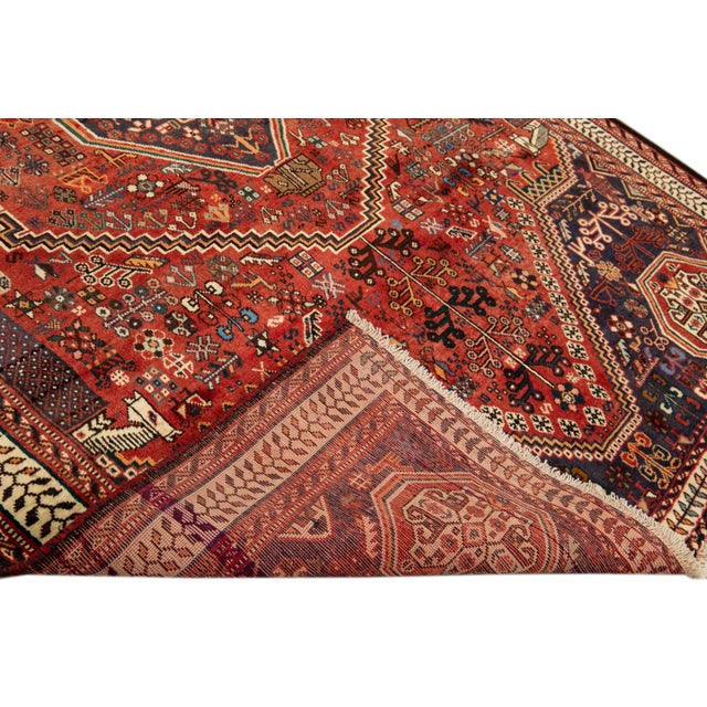 Beautiful Antique Persian Herz Handmade Wool rug with an all-over red field. This piece has multi-color accents in a...