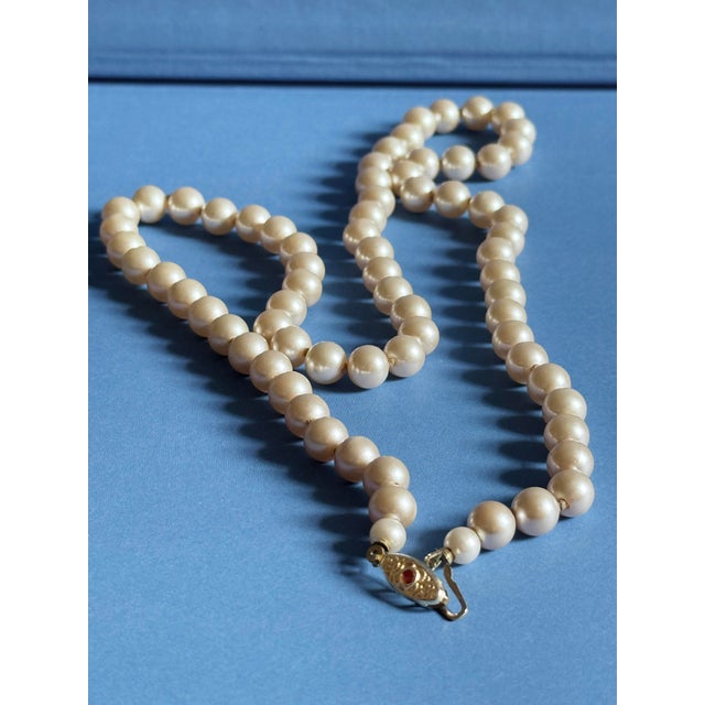Vintage Mid Century Japanese single strand necklace featuring lustrous faux pearls individually knotted along the strand...