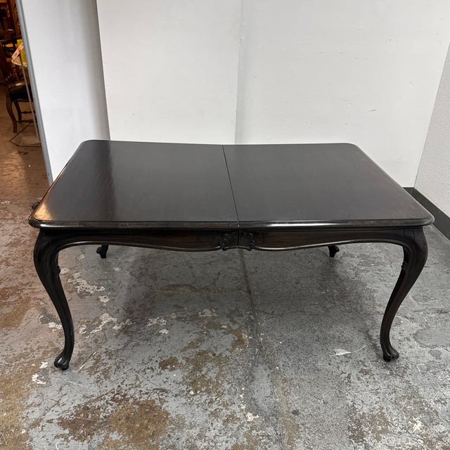 Design Plus Gallery presents a Louis XV Style Wood Extension Dining Table. The table has a rectangular wood top with...