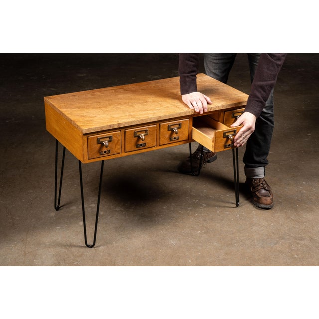 Vintage wooden library card catalog repurposed as a distinctive console or occasional table. The oak case features a...