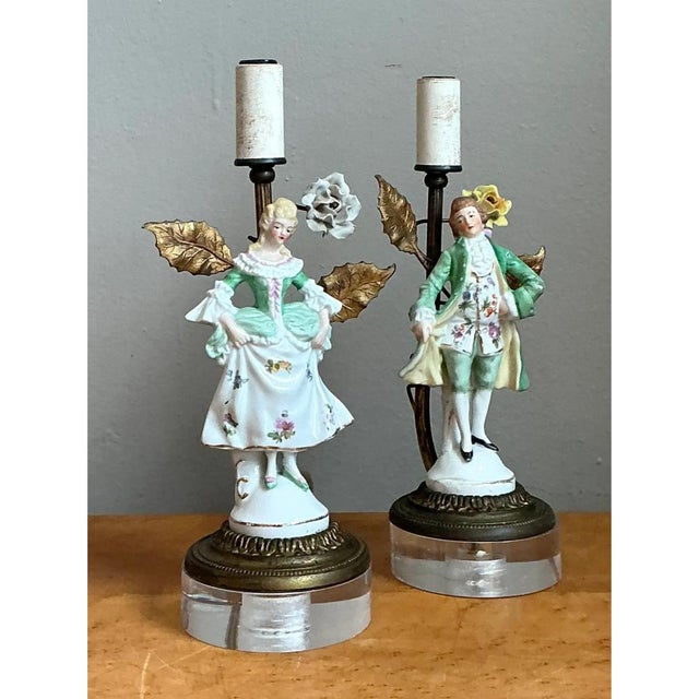 This pair of figural lamps captures a courting couple rendered in fine bisque porcelain, dressed in elegant 18th-century-...