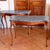 A stylish pair of slender console tables, of warm golden toned satinwood paired with chic dark gray custom marble tops....