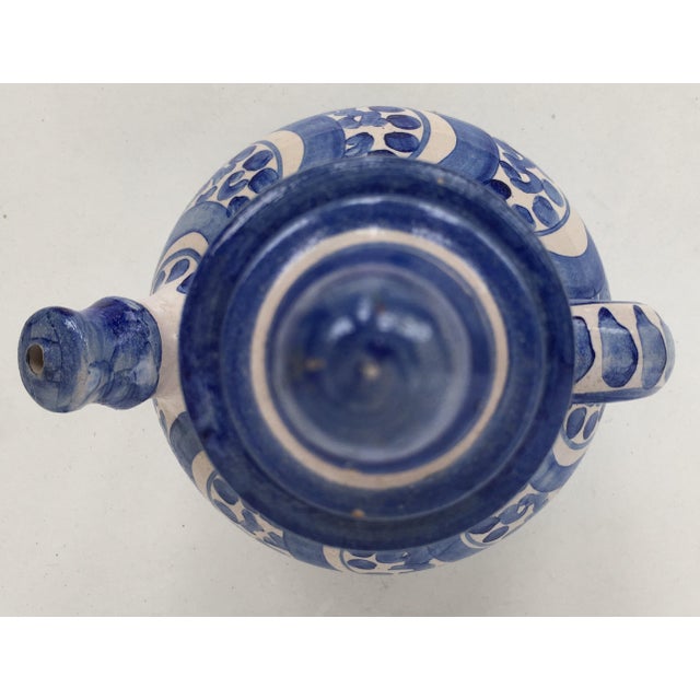 About A striking Spanish glazed earthenware handled blue and white painted pitcher , the body underglaze blue ornamental...