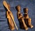 These three vintage hand-carved folk art figurines depict stylized human forms sculpted out of a single block of dynamic,...