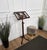 Beautiful tall floor lectern book stand with adjustable height and two carved lyre shapes standing on triod feet.