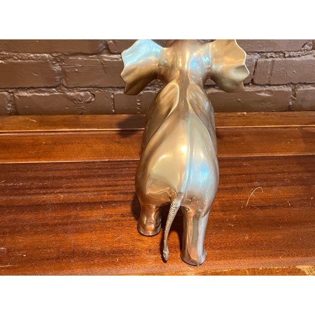 Magnificent large vintage solid brass elephant figurine featuring a detailed trumpeting trunk and flared tusks. This heavy...