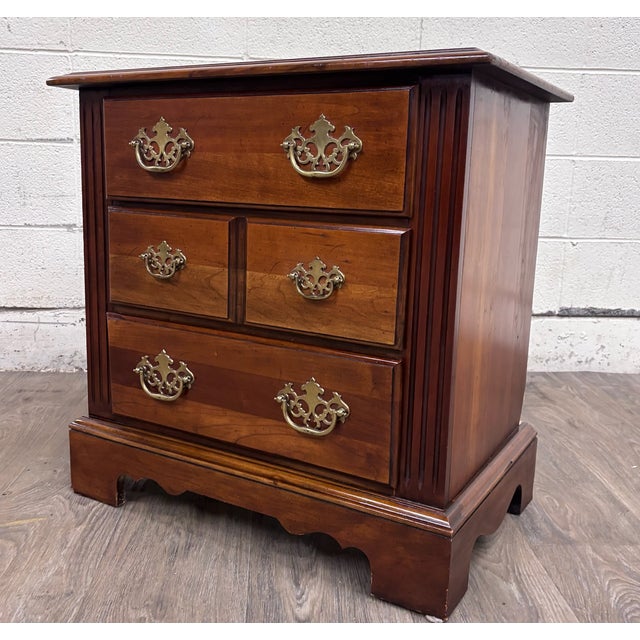 This is a vintage Broyhill Premier bachelor’s chest or nightstand featuring a warm cherry finish, four-drawer...