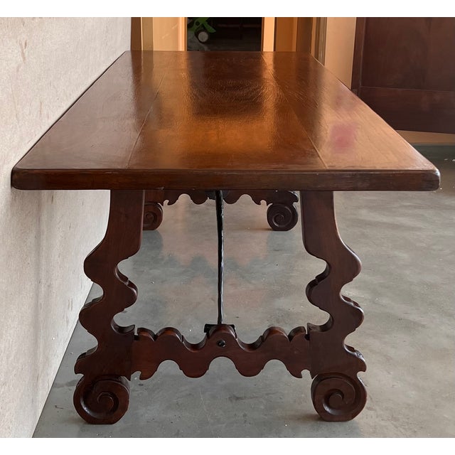 A monumental 20th century Spanish trestle table, having a rectangular framed solid walnut inset board top, resting on hand...
