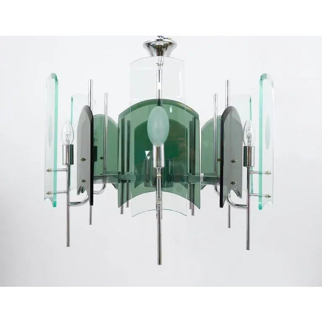 A beautiful Italian modernist chandelier with green/grey and clear faceted glasses mounted on a chrome-plated six-arm...