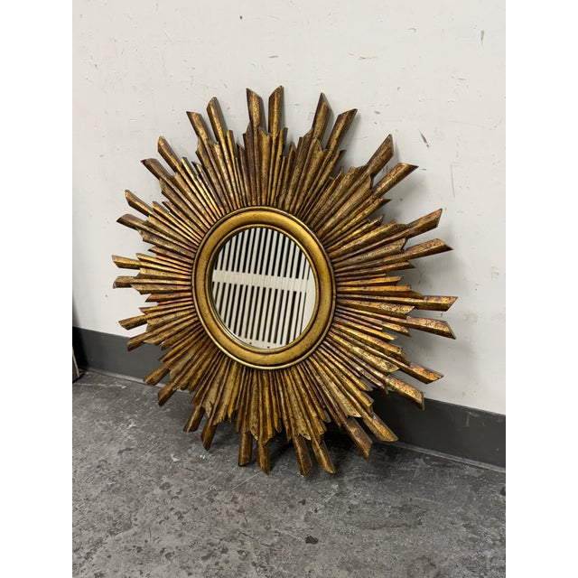 Design Plus Gallery presents a Wood Sunburst Mirror from Creative Co-Op. This round mirror has a layered radial frame in a...