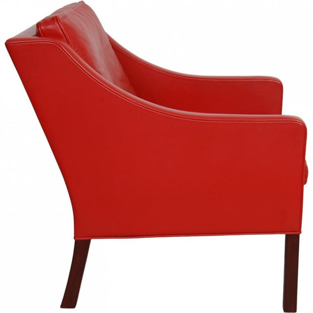 Børge Mogensen 2207 lounge chair upholstered in red leather and with legs of teak. The chair is from around 2001 and...