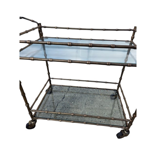 Beautiful Vintage faux bronze bar cart in excellent condition. Minor ware. Please note the glass top is clear because you...