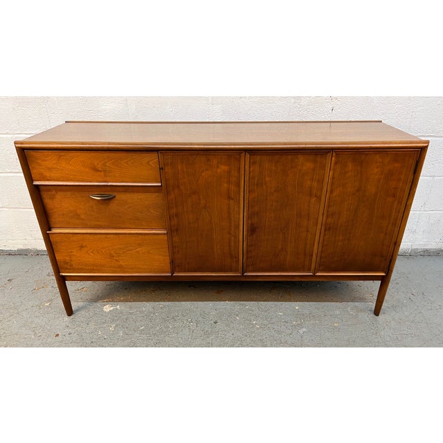 A timeless icon of American Mid-Century Modern design, this Barney Flagg for Drexel "Parallel" walnut credenza showcases...