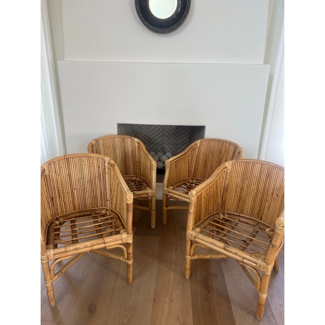 A striking set of four vintage McGuire Furniture barrel-back dining chairs featuring the California maker’s signature...