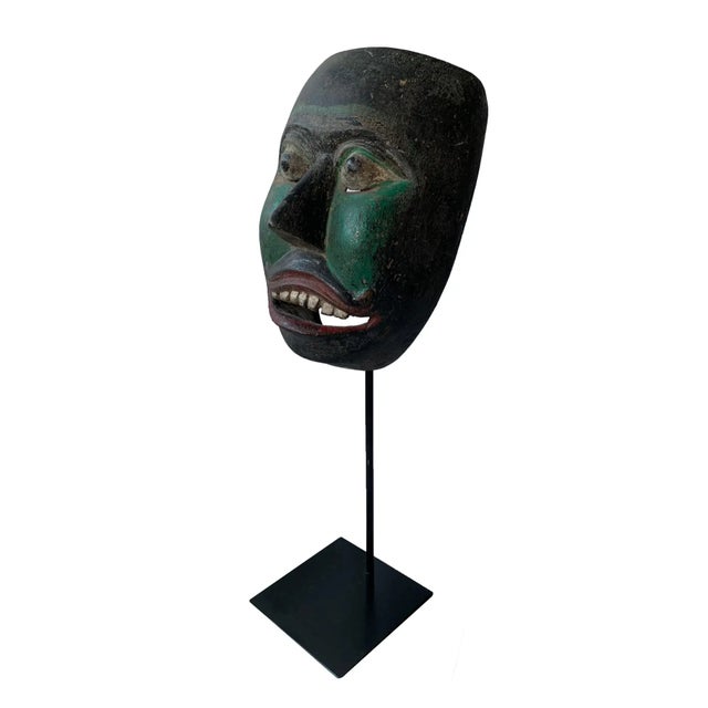 This early 20th century ‘Wayang topeng’ mask was used in Javanese masked dance performances. This mask features a black...