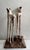 This artwork features two abstract sculptures resembling shoes, crafted from plaster and steel. The elongated forms drip...