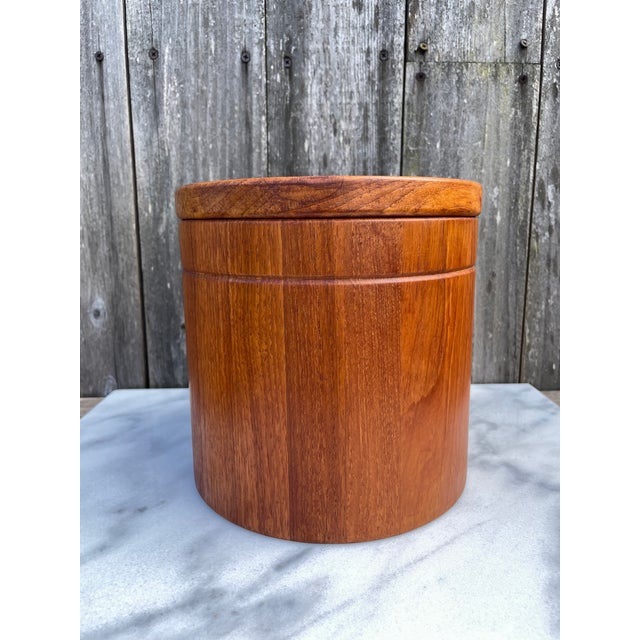 A vintage Danish Mid-Century Modern style teak ice bucket. The ice bucket features richly colored and grained teak wood...