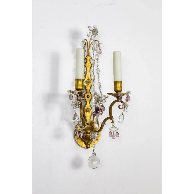 A pair of exquisite gilded brass, 2-light candlestick sconces with scroll details, variously shaped cut crystals in flower...