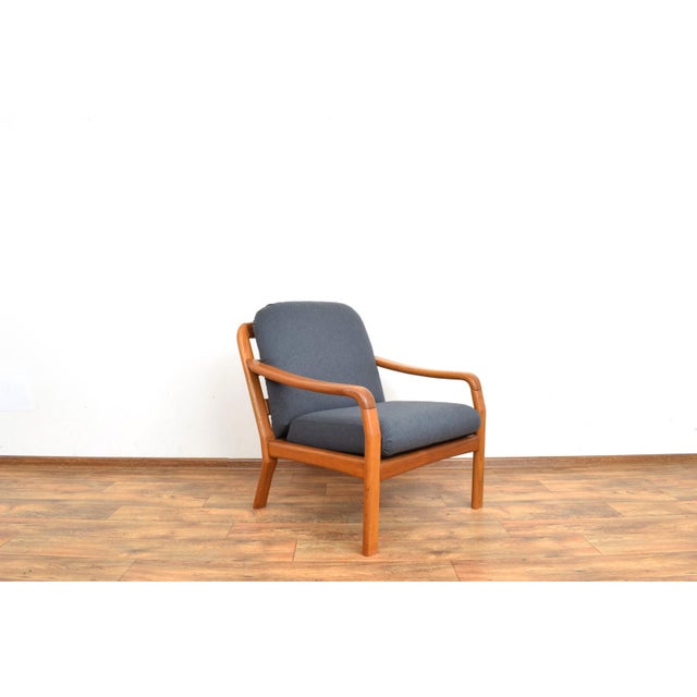 This teak armchair produced in Denmark in the 1970s by Dyrlund. The armchair frame is made of solid teak which has been...