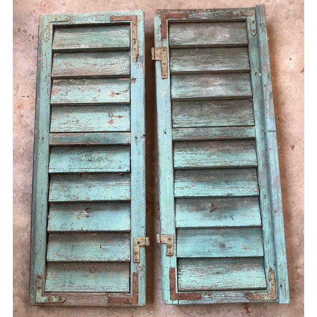 Charming pair of French wooden window shutters from the turn of the 20th Century (1900's) The shutters are painted in a...