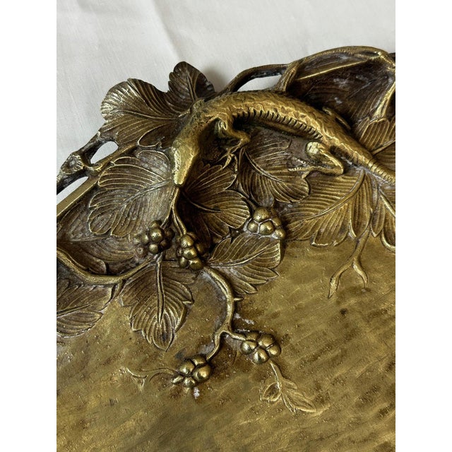 An elegant bronze trinket tray with a warm patina, dating from the Art Nouveau period, combining decorative refinement and...