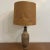Mid century table lamp with ceramic pottery base and woven lamp shade glazed in earthen tones. Height of lamp with shade...