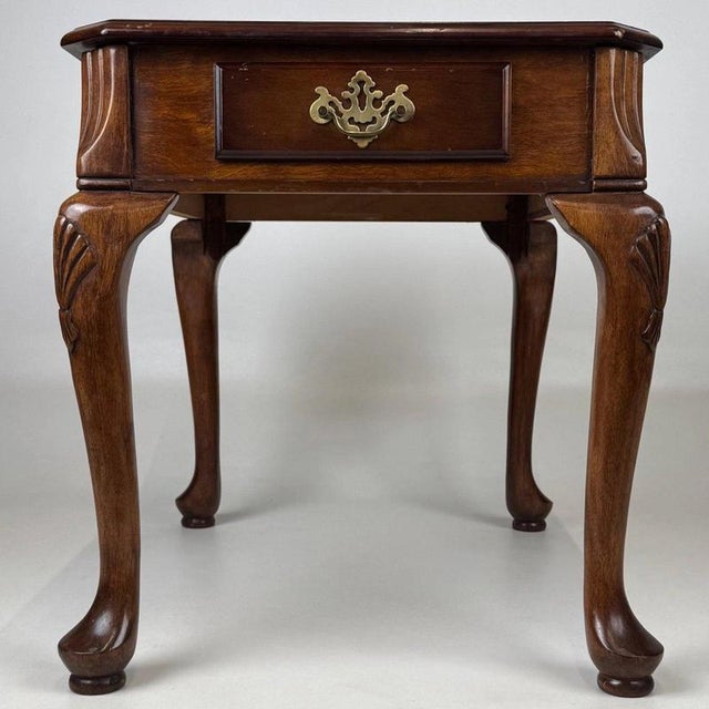 An elegant early 20th-century English side table, finely crafted from walnut and distinguished by its beautifully figured...