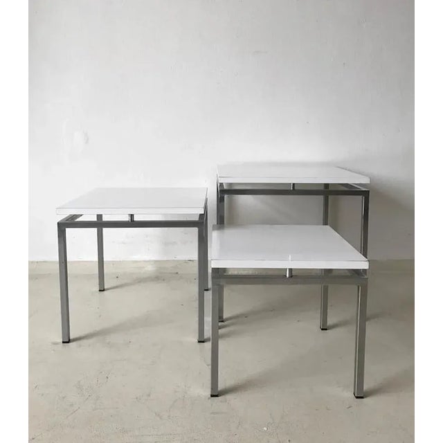 Set of three nesting tables designed by Stiemsma during the 1960s. They come with a metal base and white tops attached to...