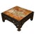 A vintage Asian square coffee table with a black lacquer fretwork base and a multicolored onyx stone top