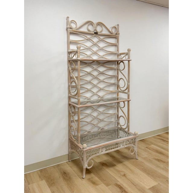 This gorgeous vintage Henry Link whitewashed rattan three-tier glass shelf etagere is a beautifully crafted and highly...