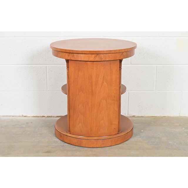 A gorgeous Regency or Neoclassical style carved cherry wood three-tier drum side table By Henredon USA, Late 20th Century...