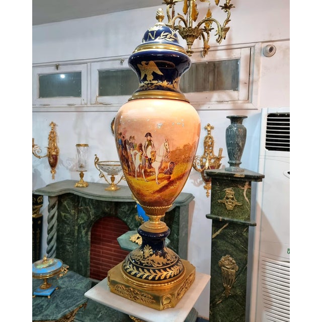 This exceptional French style porcelain vase features a striking panoramic artwork depicting Napoleon leading his troops,...