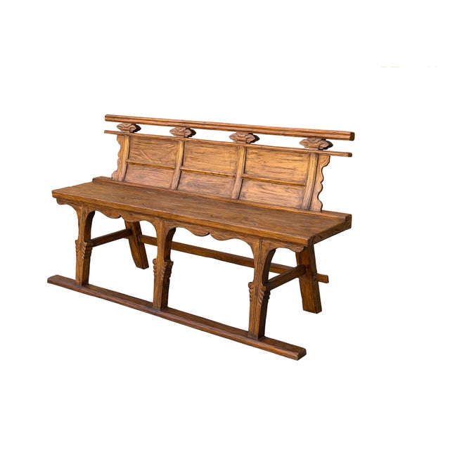 This architectural wooden bench features a robust, elongated design characterized by its rustic charm and traditional...