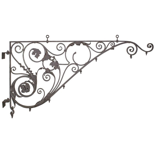 Elegant and large scale late 19th century painted wrought iron sign bracket having intricate tendril-like scrolled...