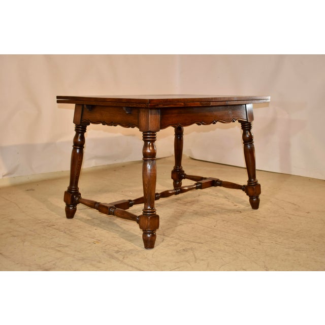 Circa 1900 oak table with two draw-leaves from France. The top and leaves are banded and follow down to a simple and...