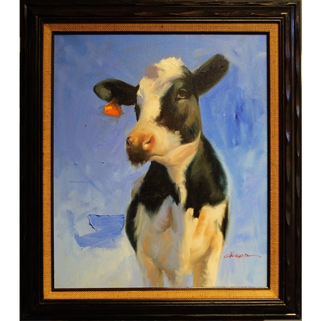 This oil on canvas painting features a striking black and white cow set against a vibrant blue background. The artist...