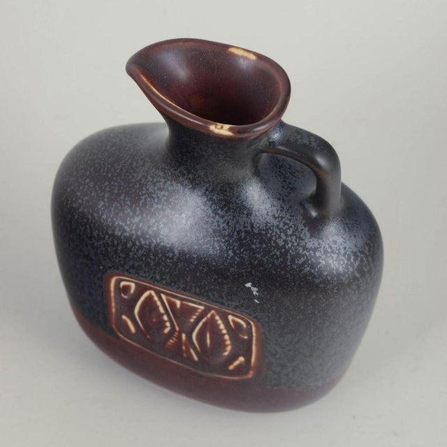Gunnar Nylund for Rörstrand, pitcher. Compact and well-balanced stoneware pitcher with a rounded, sculptural body....