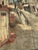 Vintage decorative tapestry featuring a charming European village street scene. The artwork depicts narrow cobblestone...