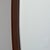 Elongated oval mirror set within a deeply contoured walnut frame. The rounded profile gives substantial depth, casting...