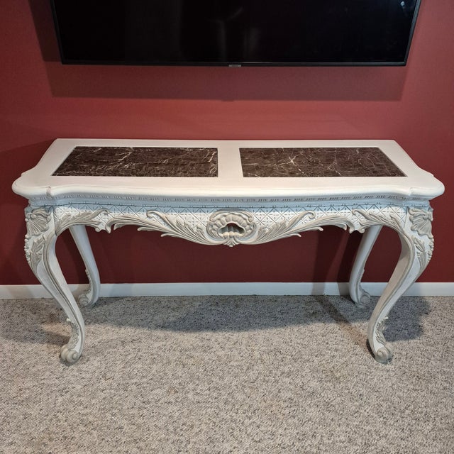 This is a beautifully carved vintage Louis XV style console table. The table measures 57” long, 20” wide, and 33” tall....