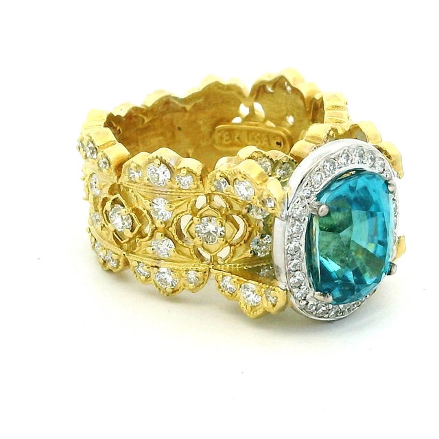 Striking designer cocktail ring by Stambolian, crafted in solid 18 karat yellow gold and centered with a vibrant oval blue...